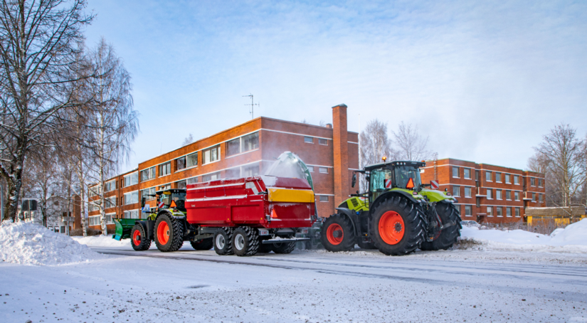 CLAAS lumilinko linkoaa lunta peräkärryyn.
