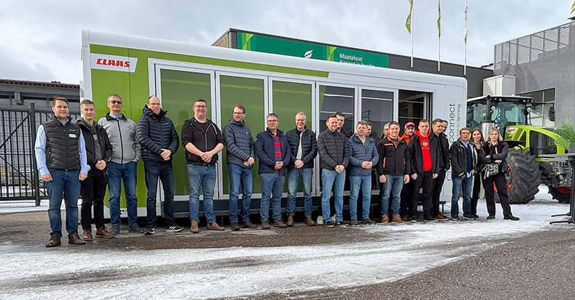 Joukko viljelijöitä ja urakoitsijoita seisomassa CLAAS-kontin edessä. Taustalla näkyy CLAAS-traktori.