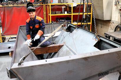 Mies hitsaa hiekoitinvaunua.