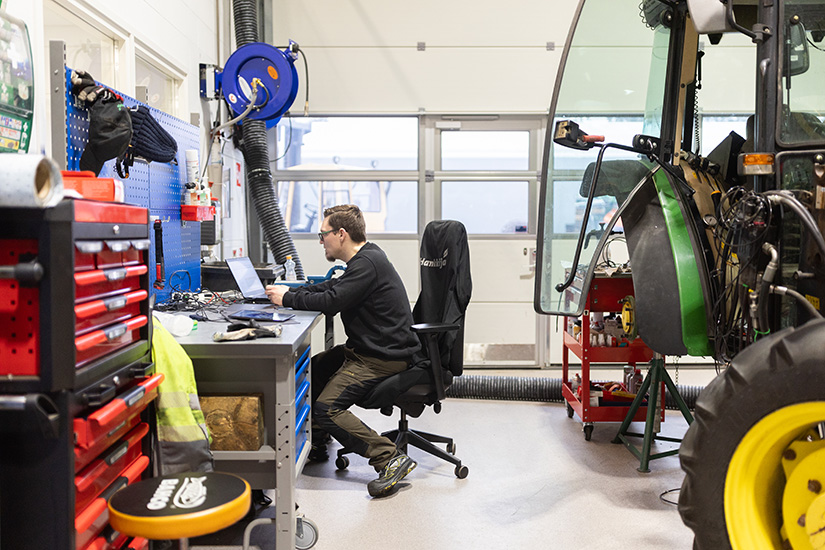 Hankkijan huoltohenkilö etsii varaosia vanhempaan Junkkariin tietokoneelta.