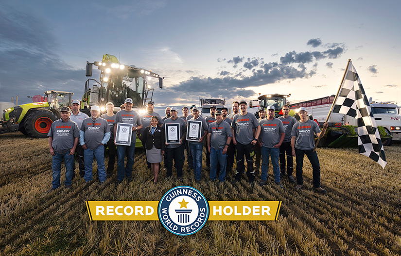 Claasin henkilökuntaa seisoo pellolla pitäen Guinness World Records -titteleitä maailmanennätyksestä.