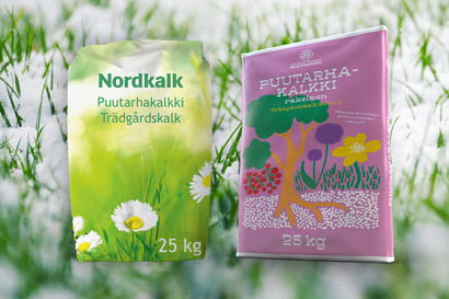 Kaksi 25 kg puutarhakalkkipussia, vasemmalla vihreä Nordkalkin pussi ja oikealla vaaleanpunainen Multasormen pussi.