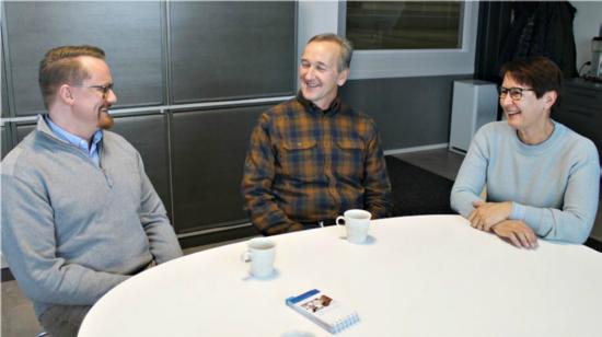 Jussi Saranen sekä Tiina ja Tarmo Lankinen pöydän äärellä.