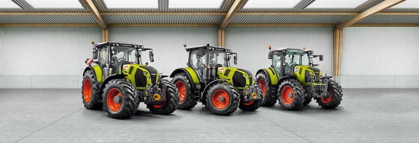 Kolme Claas-traktoria konehallissa.