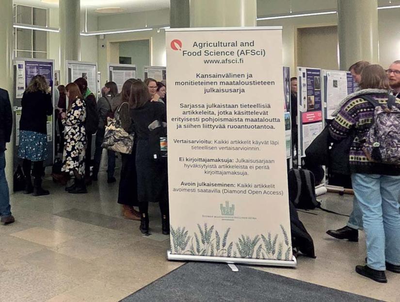 Maataloustieteen päivien posterinäyttely, jossa osallistujat tutustuvat tutkimuspostereihin aulatilassa.
