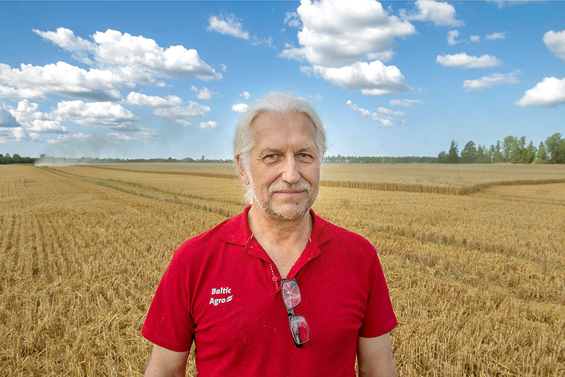 Markus Ameerikas hymyilemässä punaisessa t-paidassa pellolla puolipilvisenä kesäpäivänä.