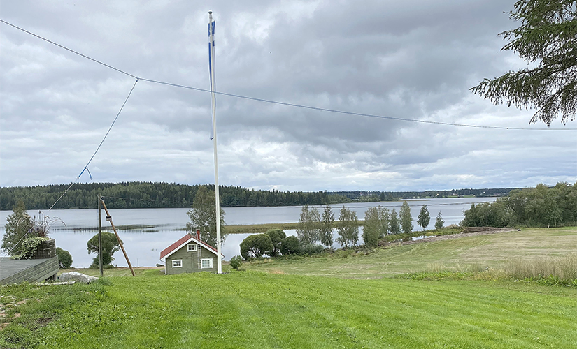 Laukkasten maatilan vihreä nurmi lipputangolla pilvisenä kesäpäivänä