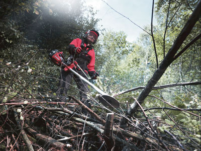 Mies raivaa metsää raivaussahalla